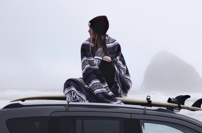 transport planche de surf : planche de surf bien fixée sur les barres de toit d'une voiture