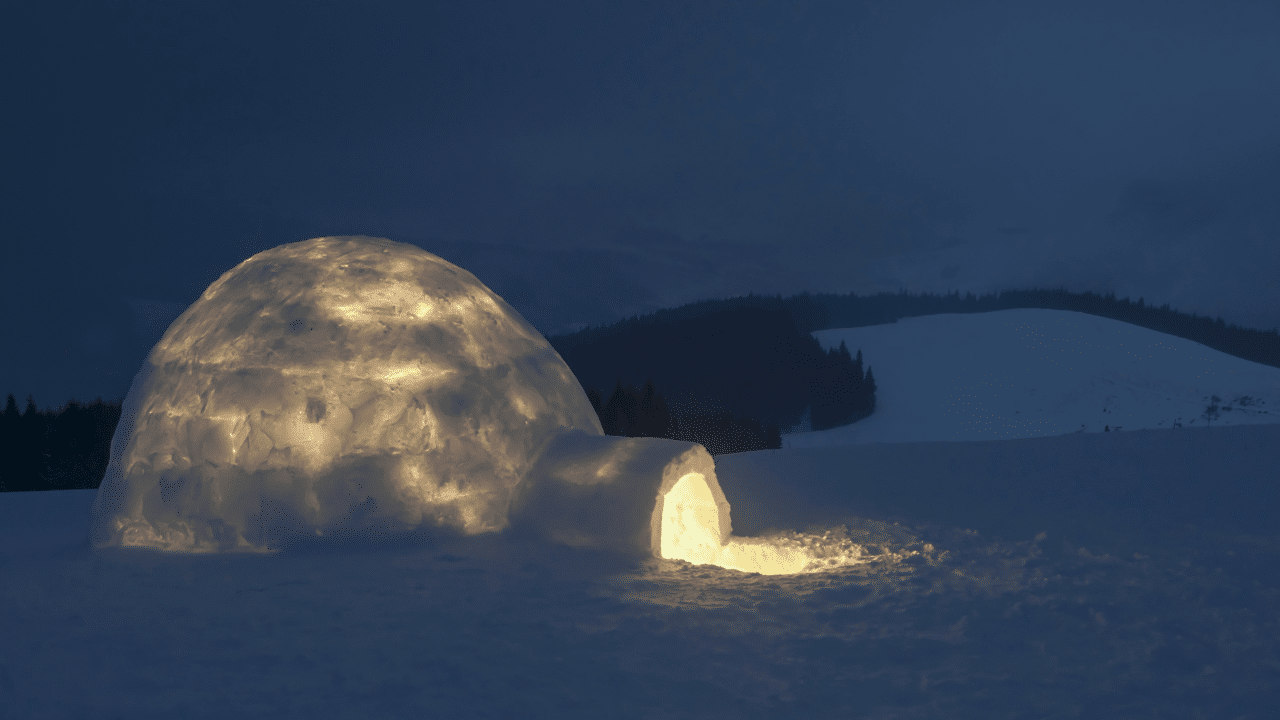 igloo : personne construisant un igloo avec des blocs de neige